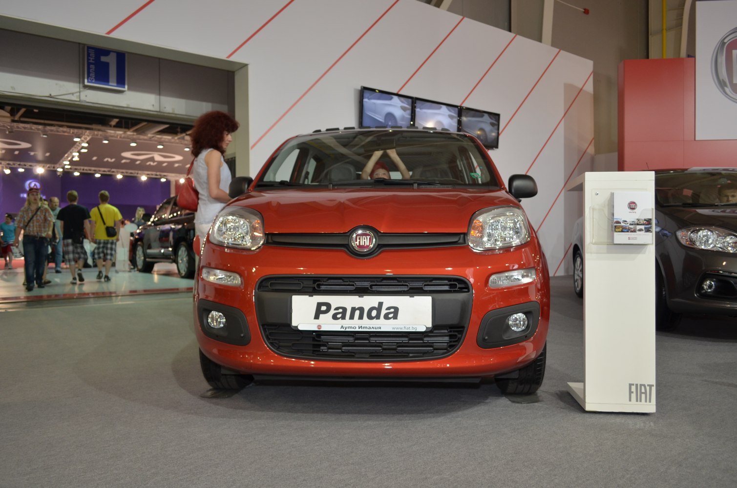 Front view of red compact vehicle with round headlights and black grill