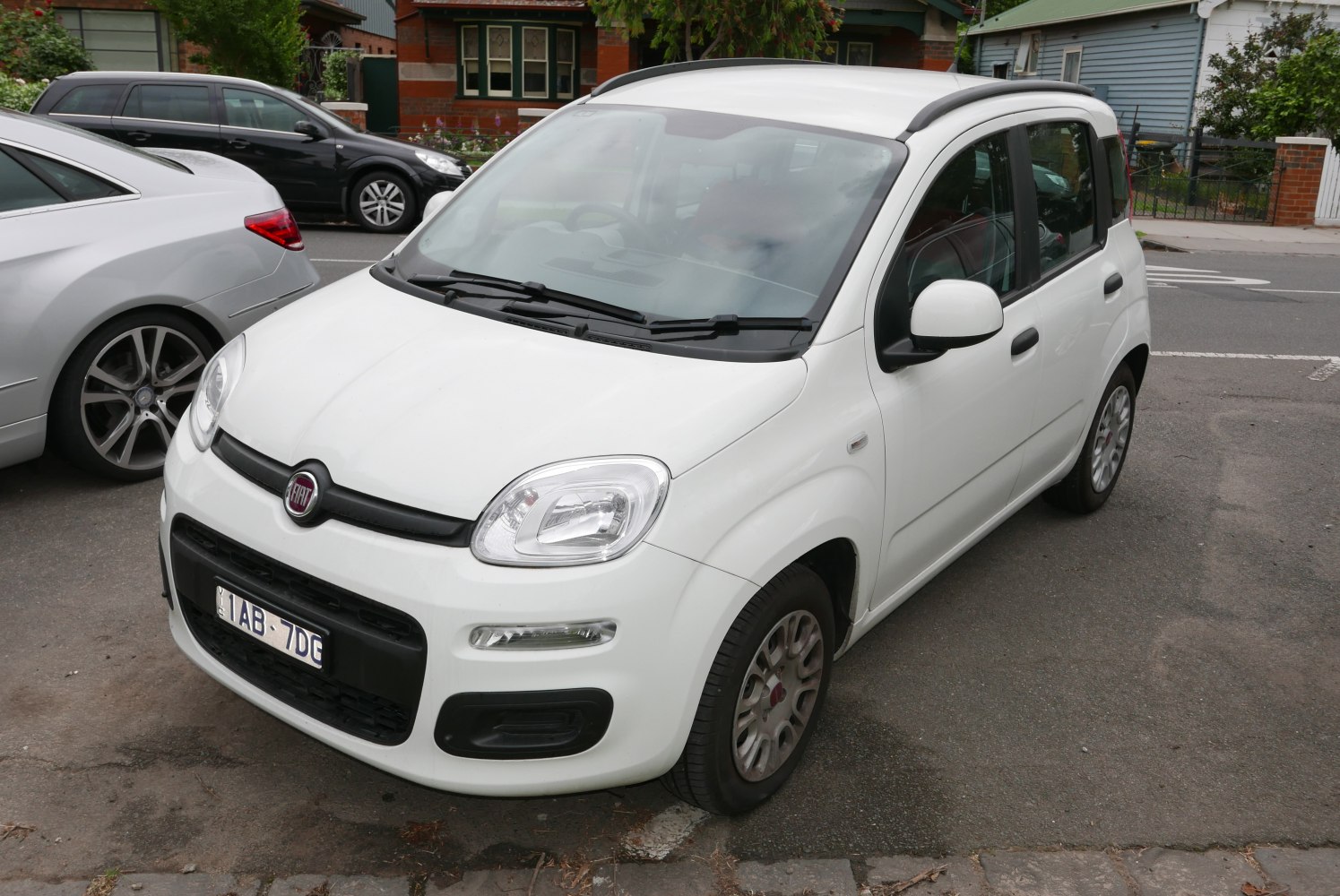 Compact white city car with rounded front and black trim details