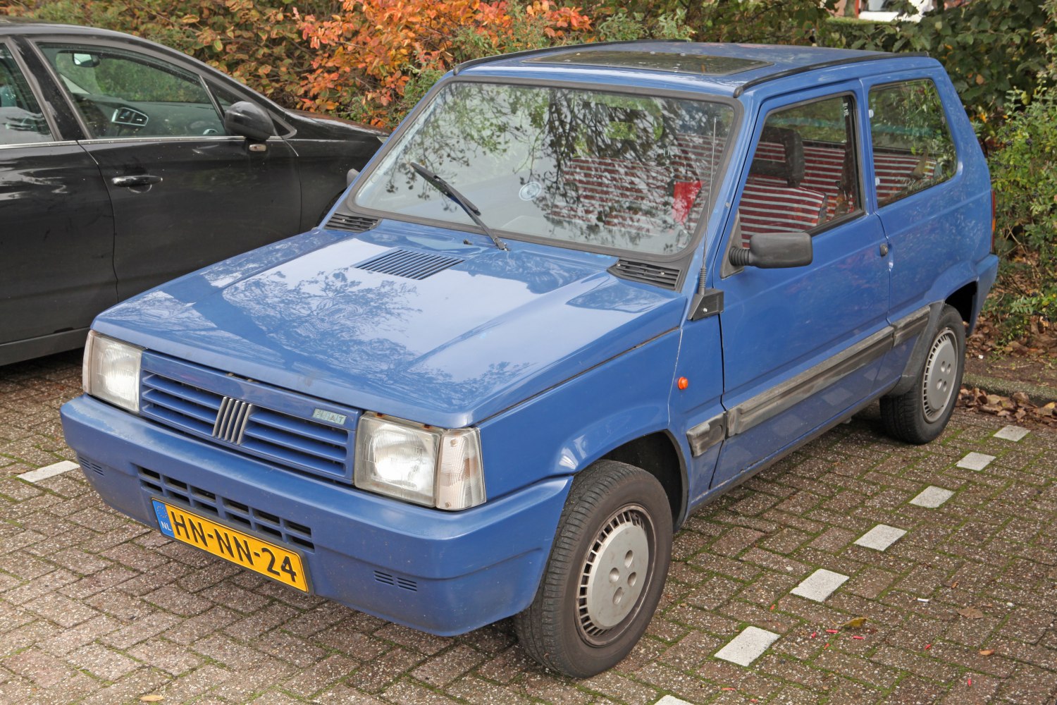 Compact blue hatchback with distinctive front grille and headlights