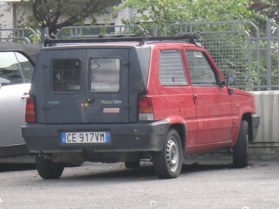 Rear side view of a compact vintage van with dual rear doors and roof rack.