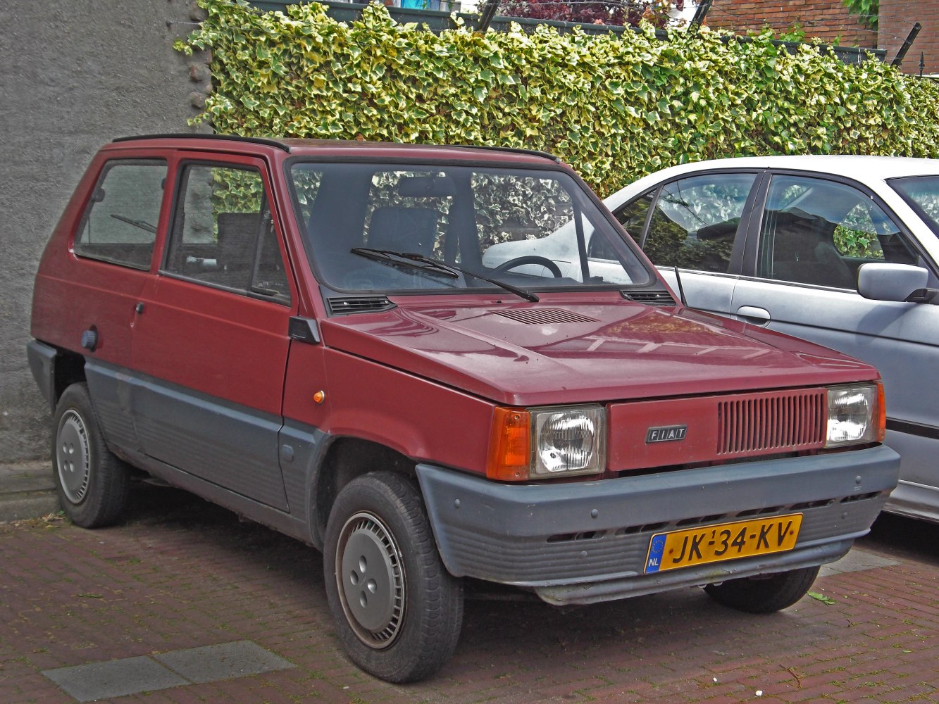 Compact hatchback with square headlights and simple front grille.