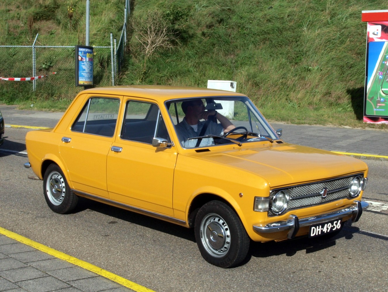 Vintage yellow four-door sedan with round headlights and chrome bumper