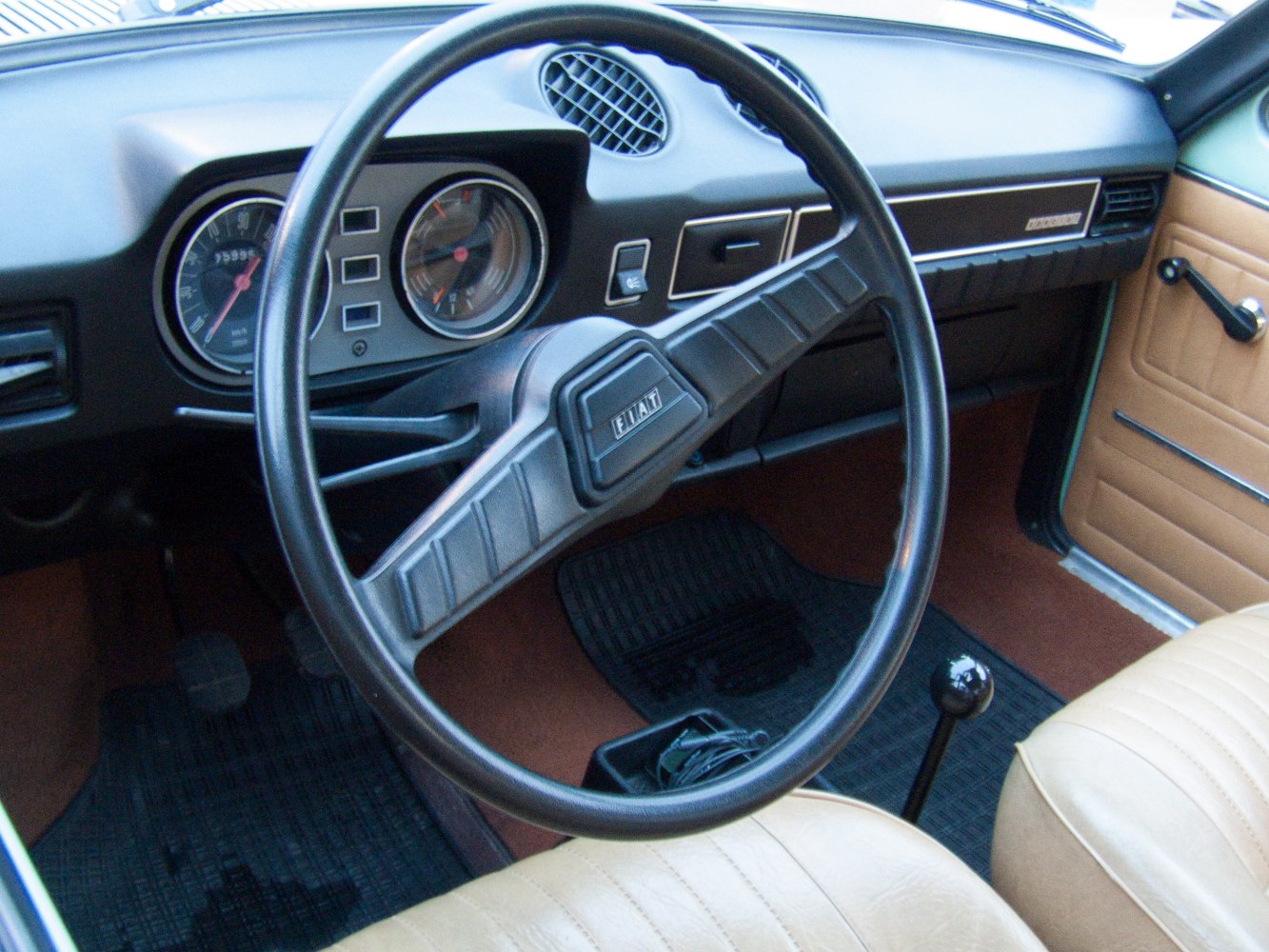 Vintage steering wheel and dashboard with analog gauges and manual gearshift
