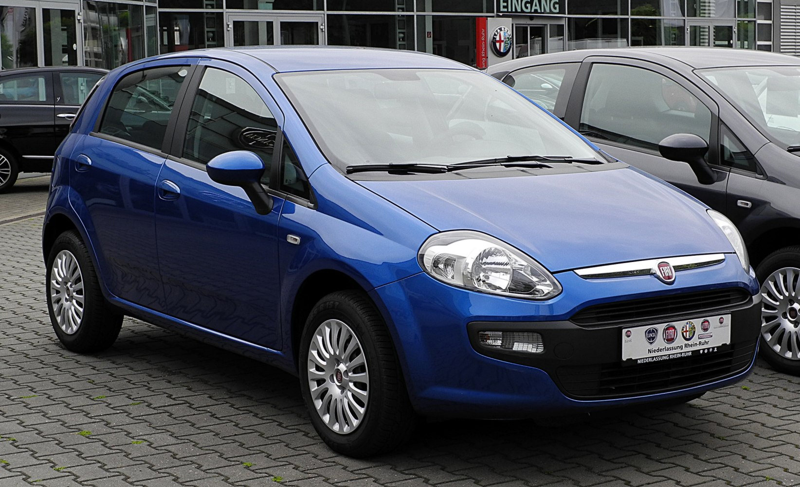 Blue hatchback seen from front side showing headlights and sleek curves