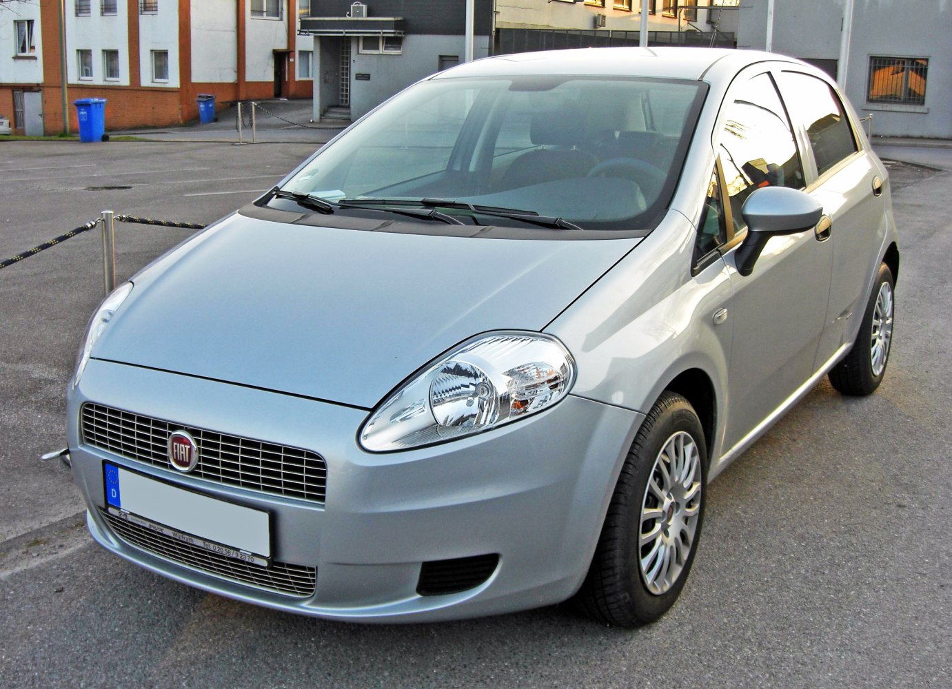 Front-side view of silver hatchback with clear headlights and grille.