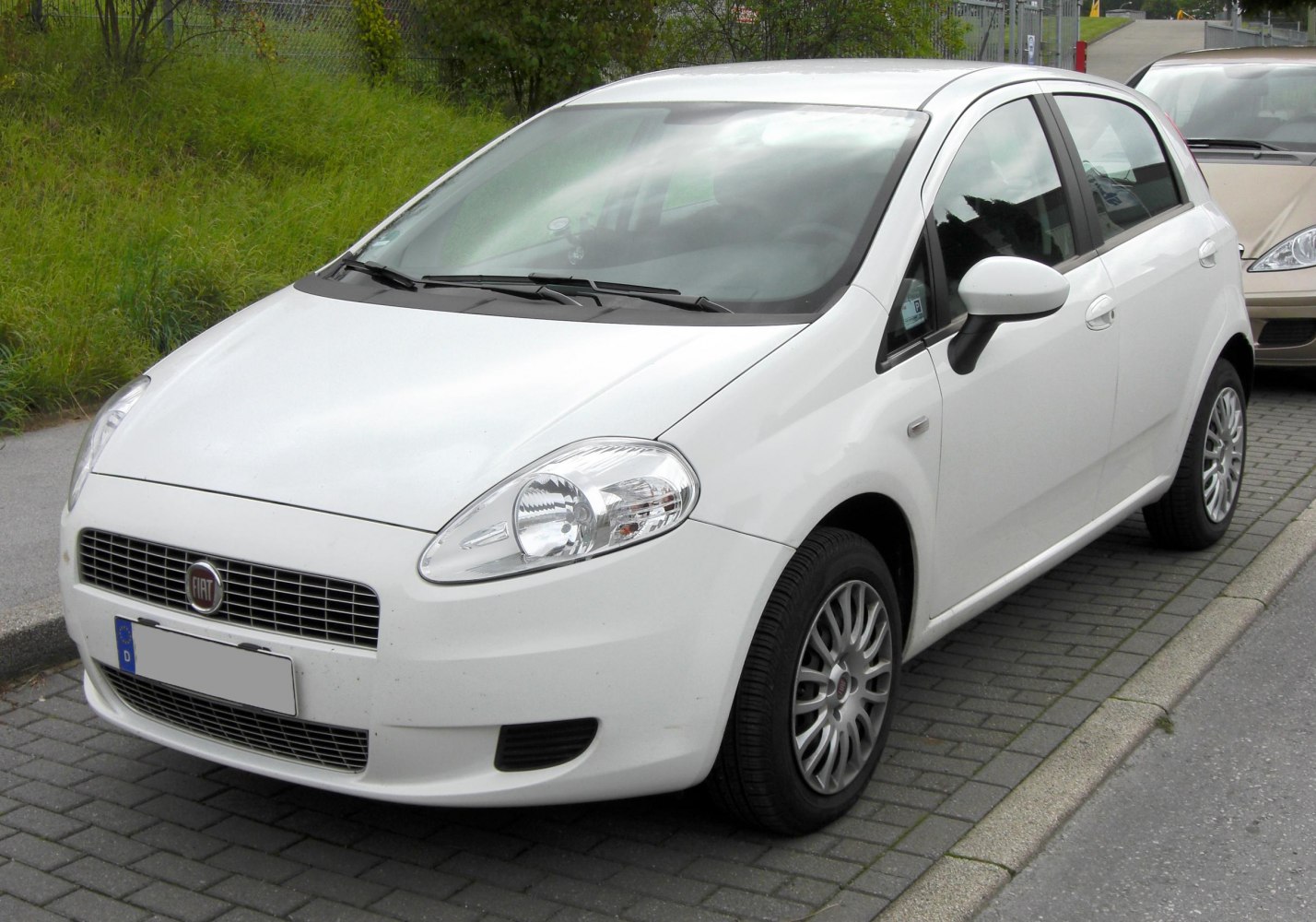 White compact hatchback front and side view with distinctive headlights and grille