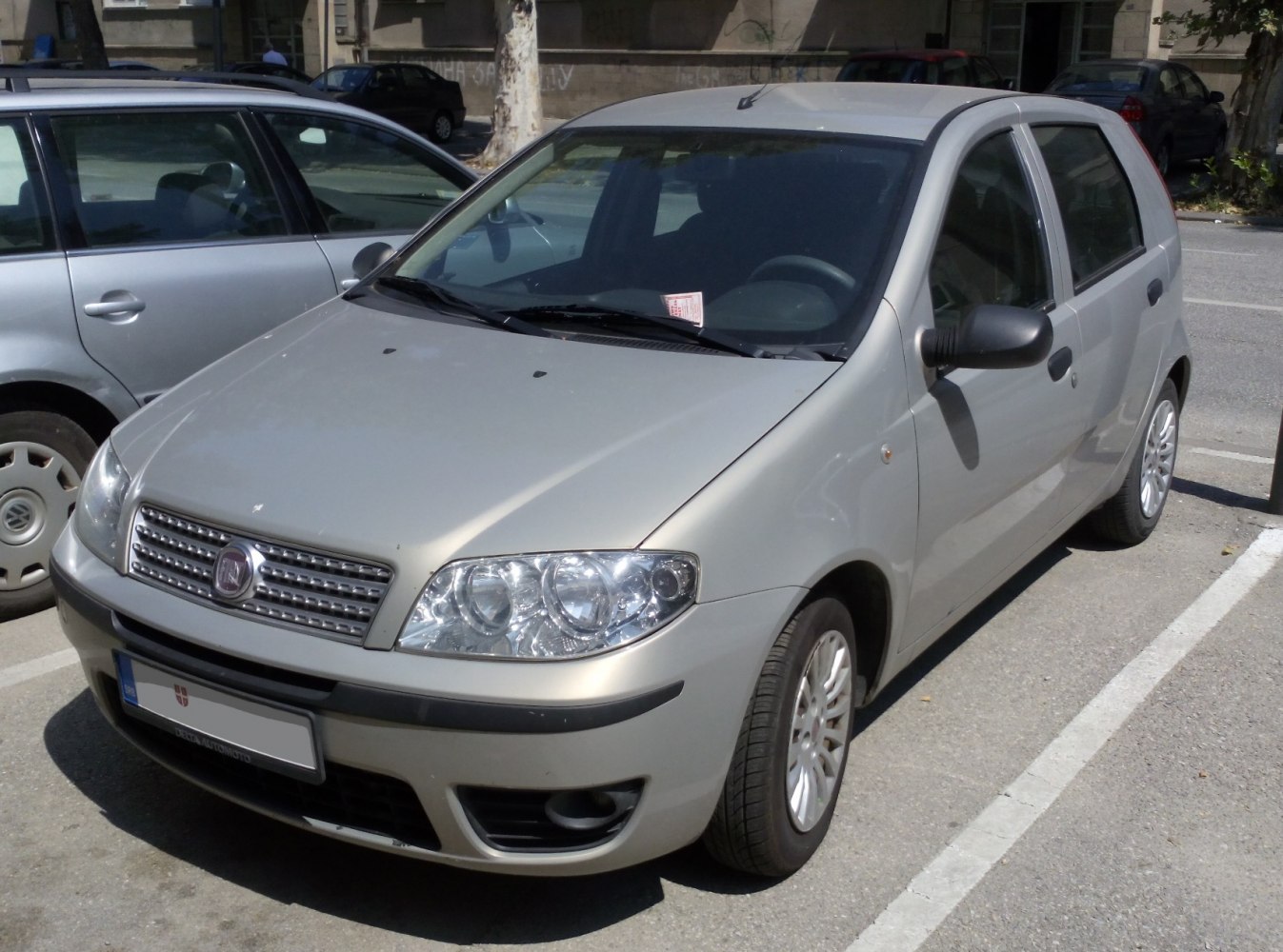 Silver hatchback front-side view with prominent headlamps and grille