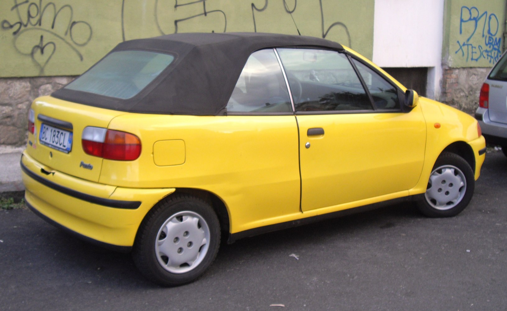 Yellow convertible hatchback with black soft top roof