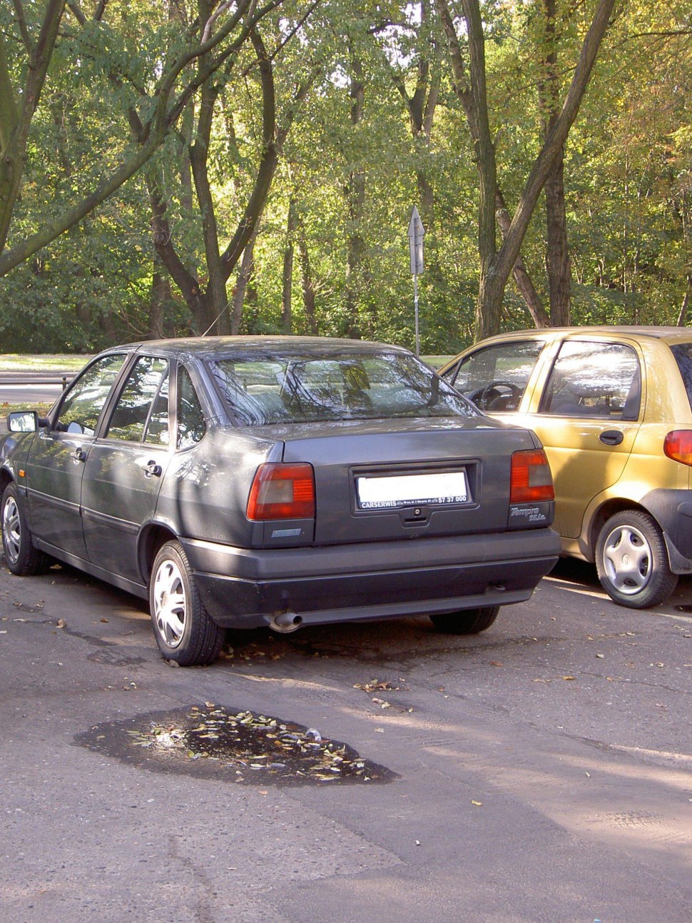 Rear view of a 1990s four-door sedan with distinct taillights and exhaust