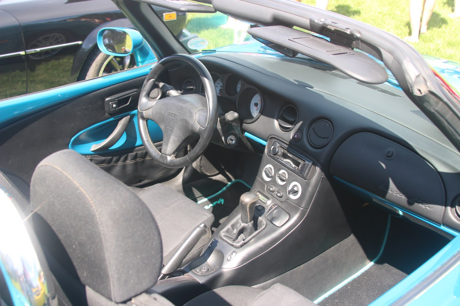 Manual transmission, steering wheel, and dashboard inside a convertible car