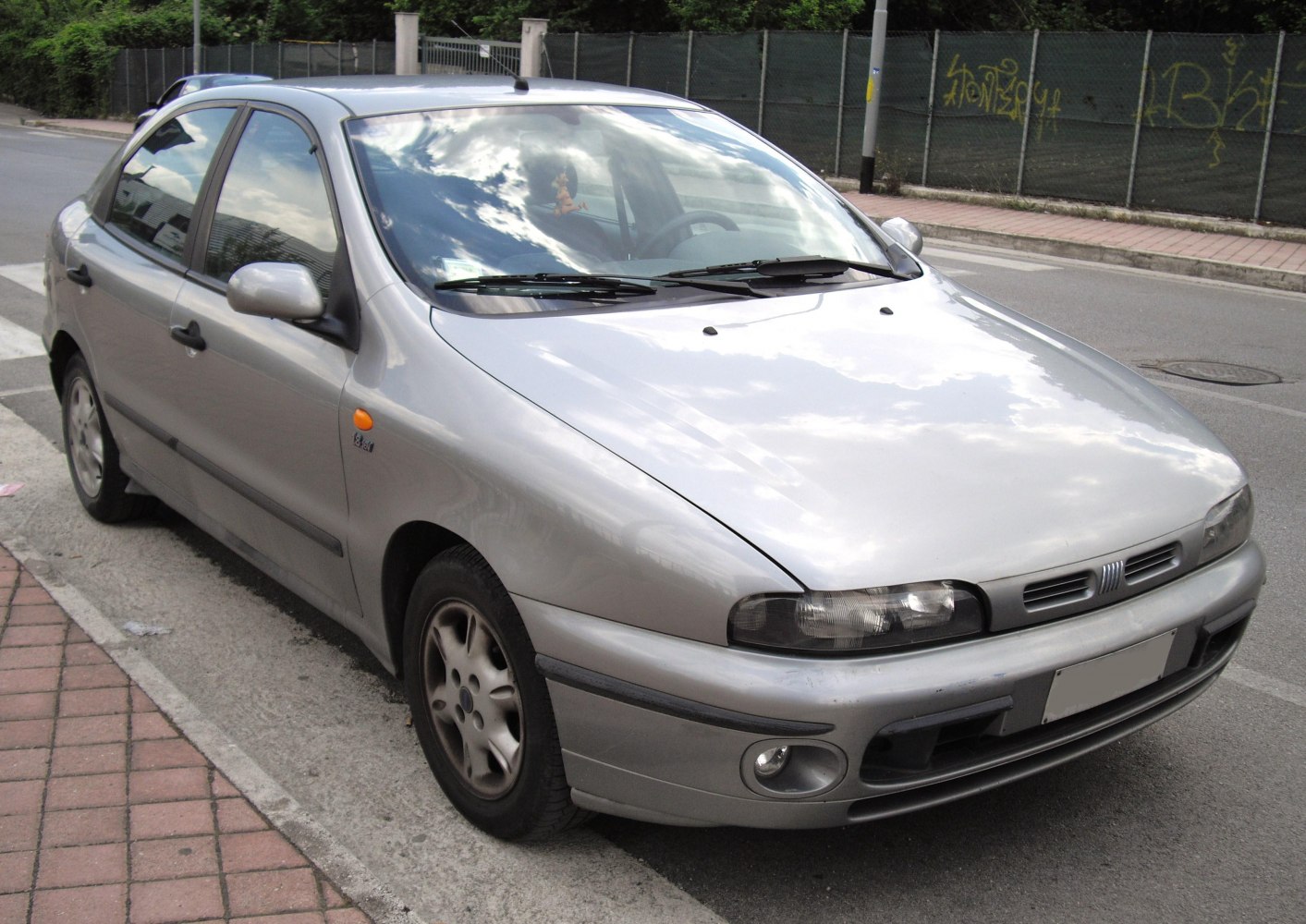 Silver compact hatchback with rounded headlights and five-spoke rims