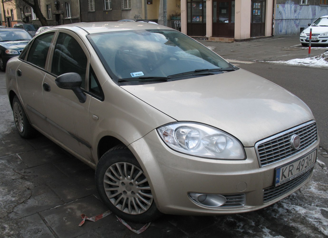 Sedan front view showing headlights, grille, alloy wheels, and side mirrors