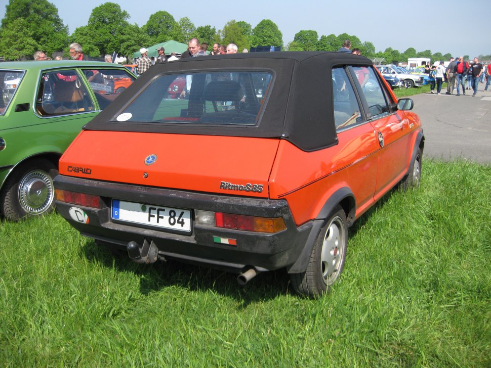 Vintage convertible rear with black soft top and rectangular tail lights.