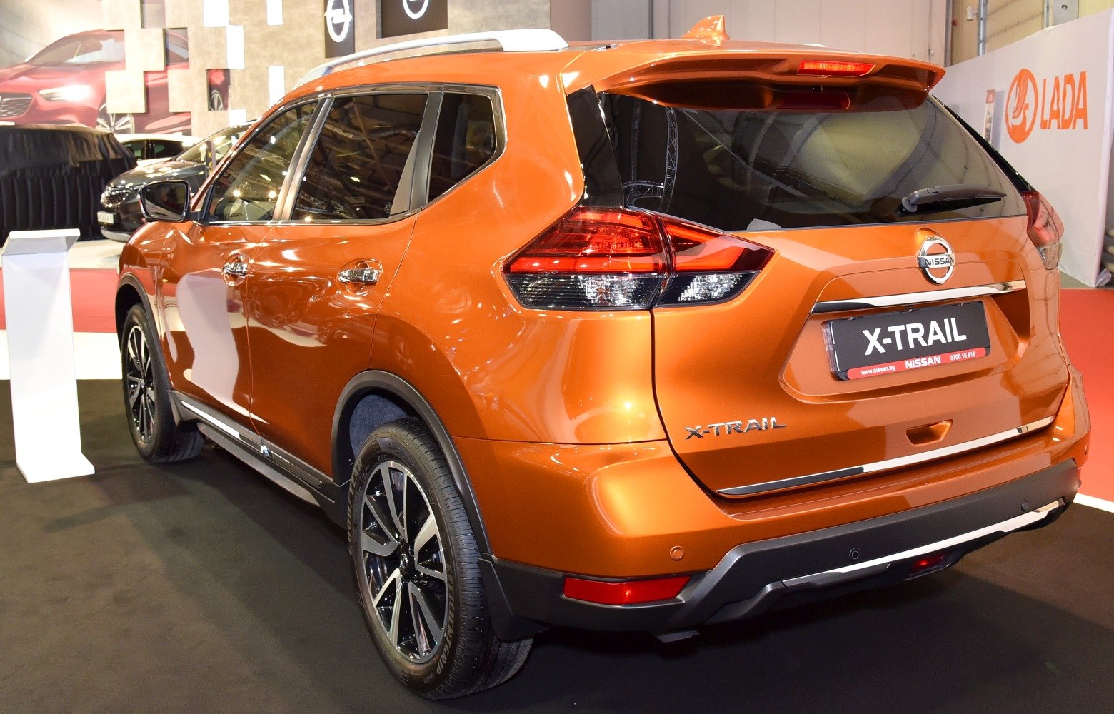 Rear and side view of an orange SUV with distinctive tail lights and alloy wheels.
