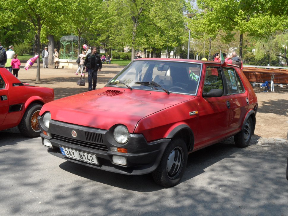 Red compact hatchback with round headlights and black bumper