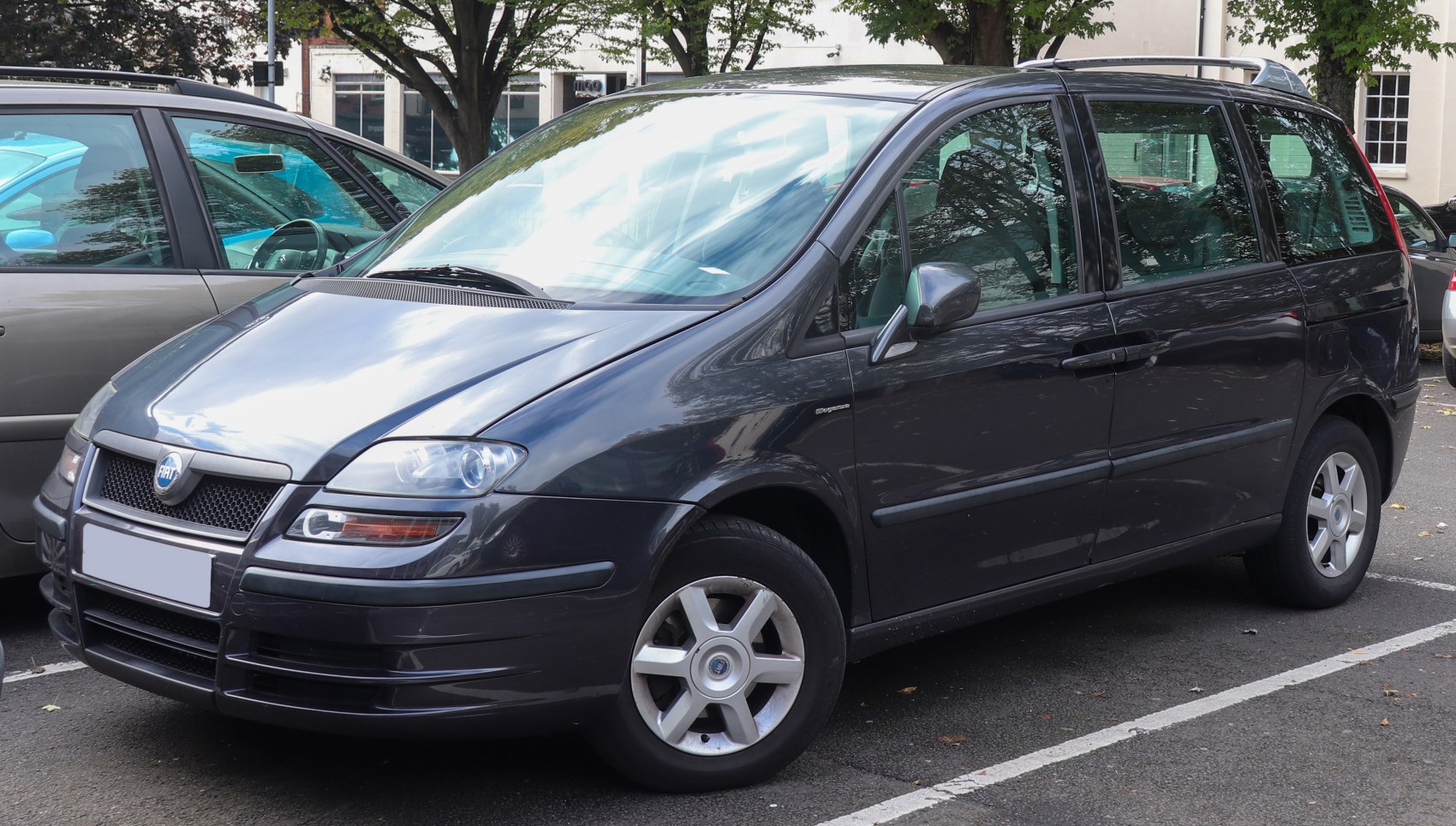 MPV front side view with distinctive headlights and dark grey finish