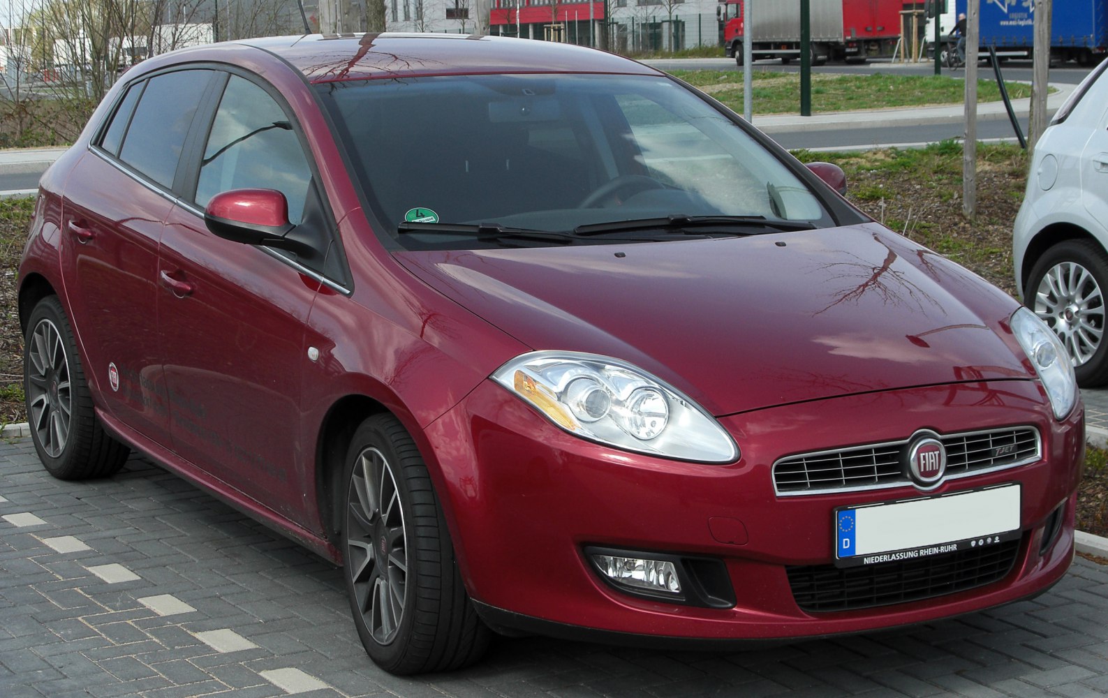 Red hatchback with prominent headlights and grille