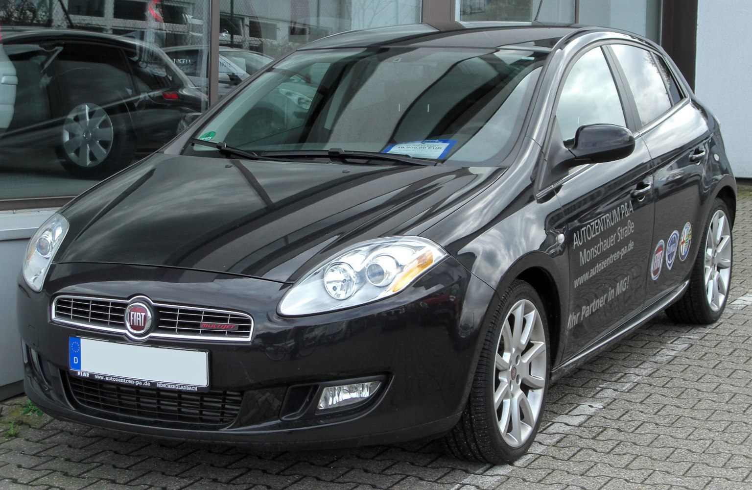 Front angled hatchback with headlights, grille, and alloy wheels
