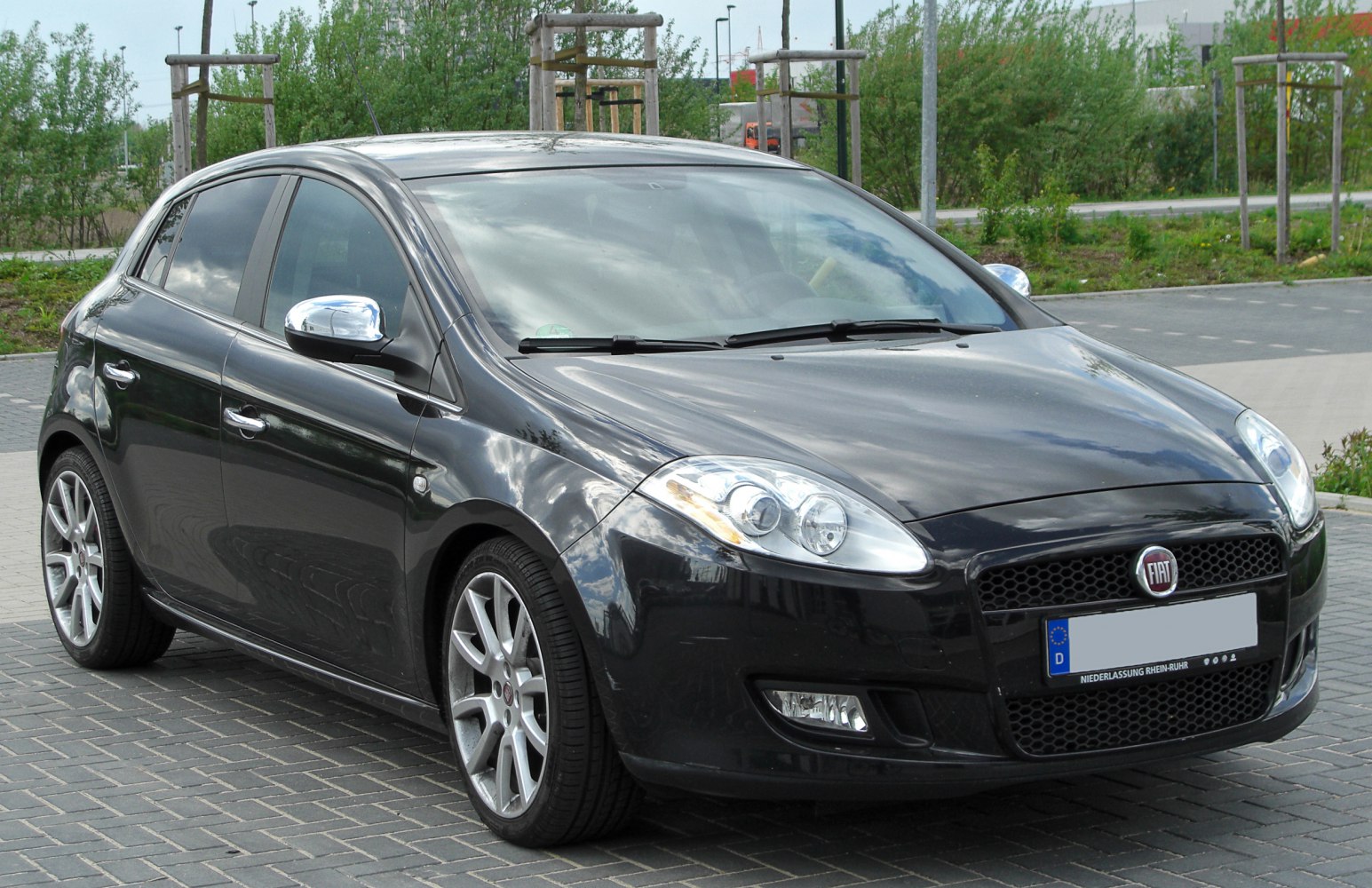 Front side view of hatchback with distinct headlights and alloy wheels