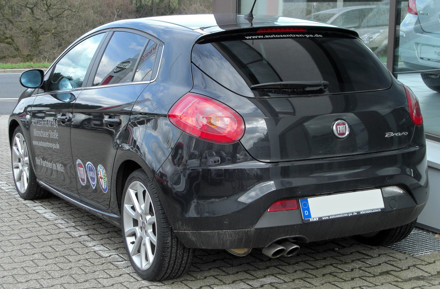 Rear hatchback view with distinctive tail lights and dual exhaust