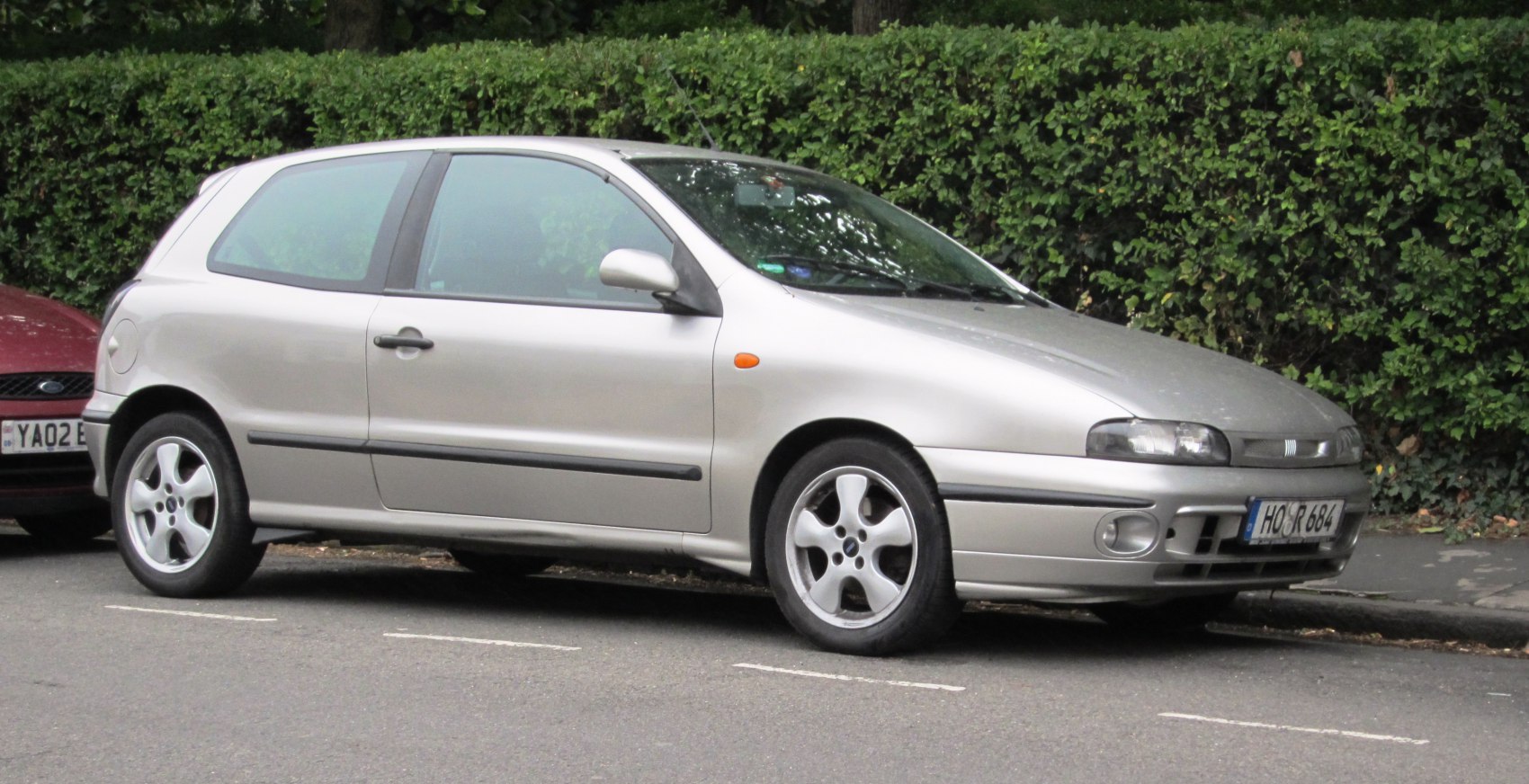 Silver 3-door hatchback with alloy wheels, side view