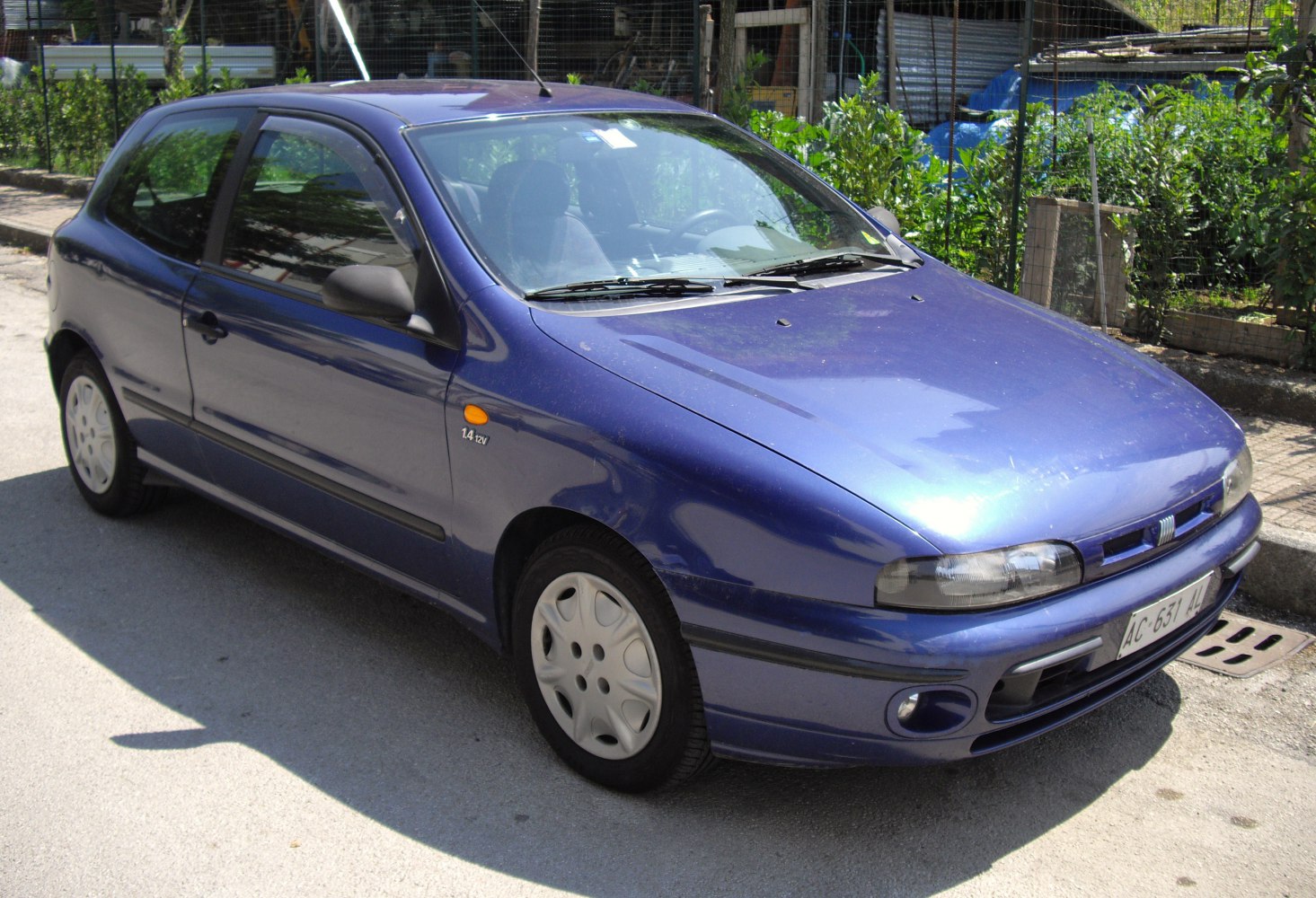 Blue compact hatchback with rounded headlights and 1.4 12V badge
