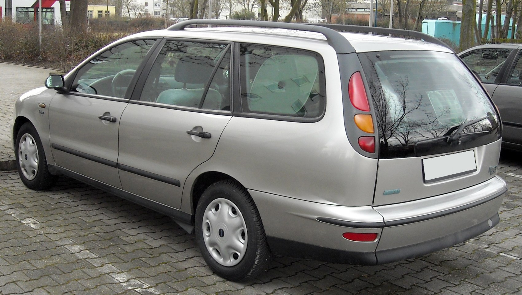 Rear-side view of station wagon with distinctive taillights and roof rails