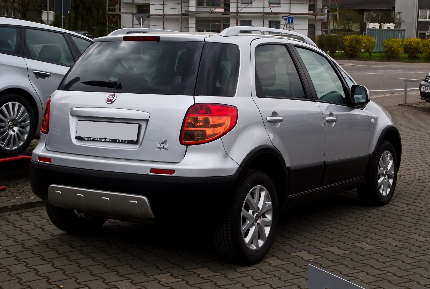 Rear and side profile of silver compact SUV with roof rails and alloy wheels