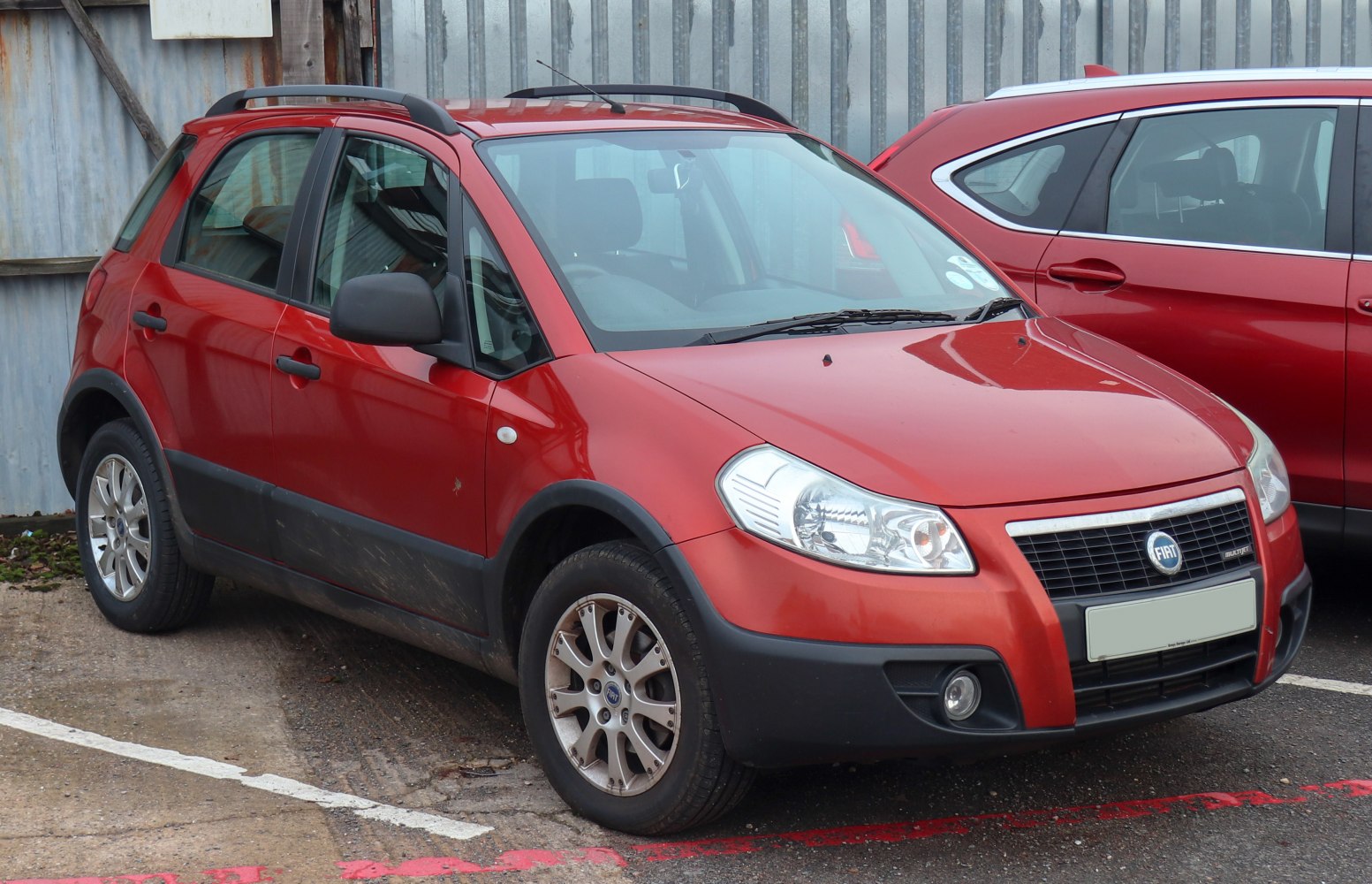 Red compact crossover with roof rails and alloy wheels
