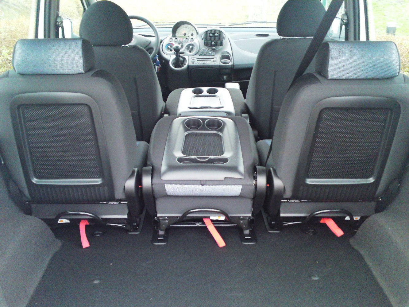Rear split seats with central fold-down armrest and integrated cup holders.