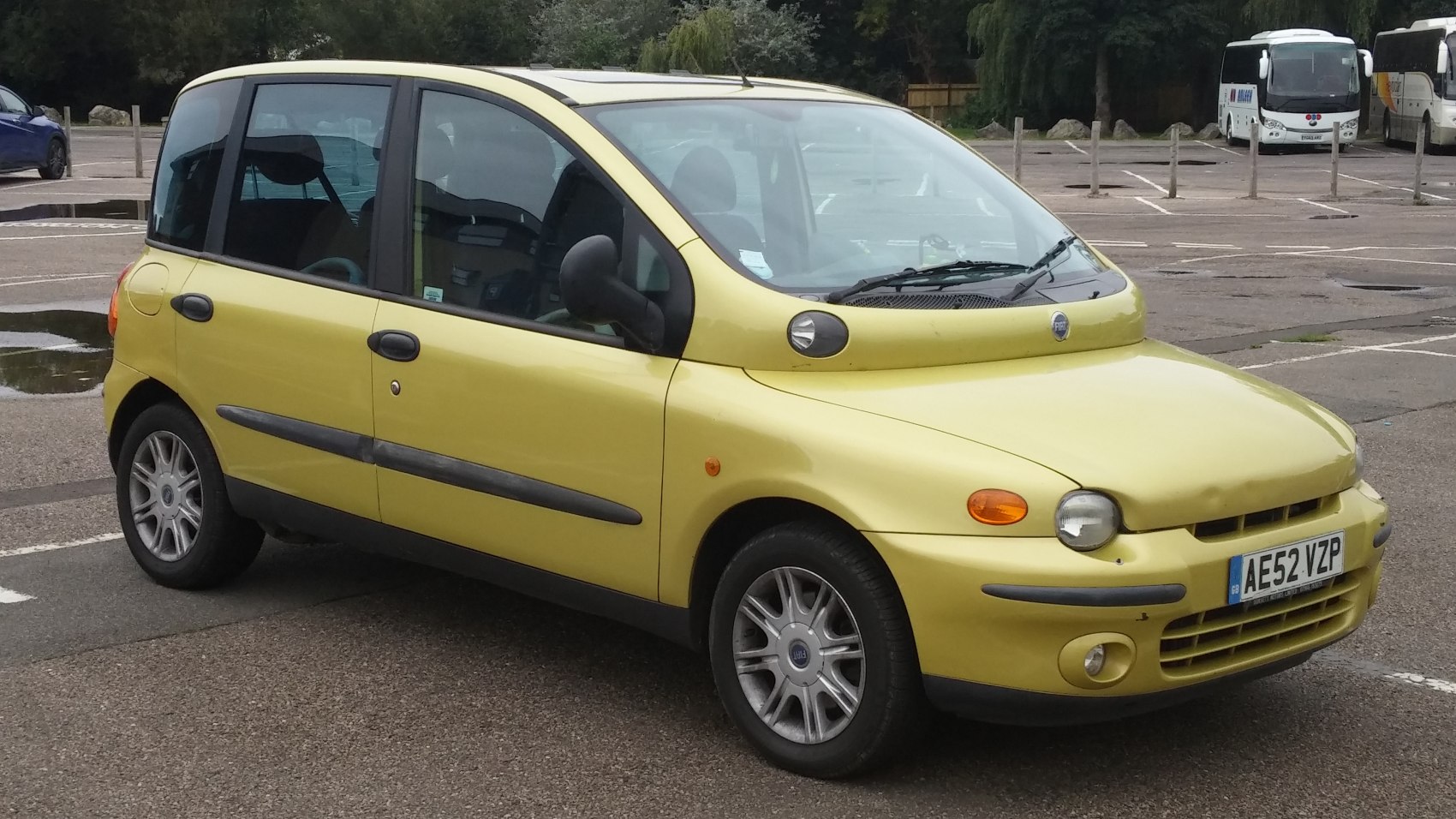 Unique front side view with distinct dual headlight design and compact multi-door body.