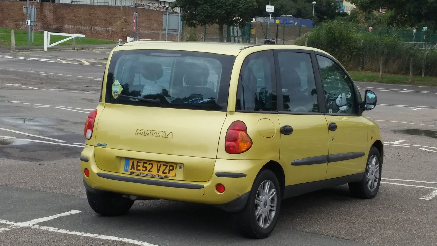 Yellow rear minivan with large rear window and distinct tail lights