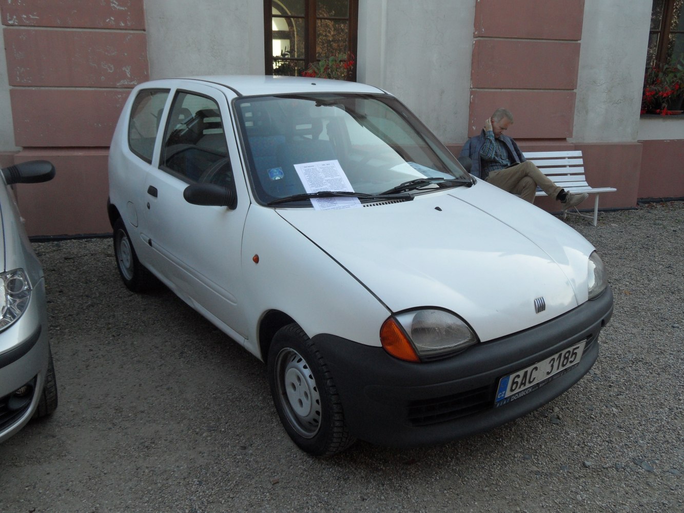 Compact white hatchback with black bumper and simple wheel covers