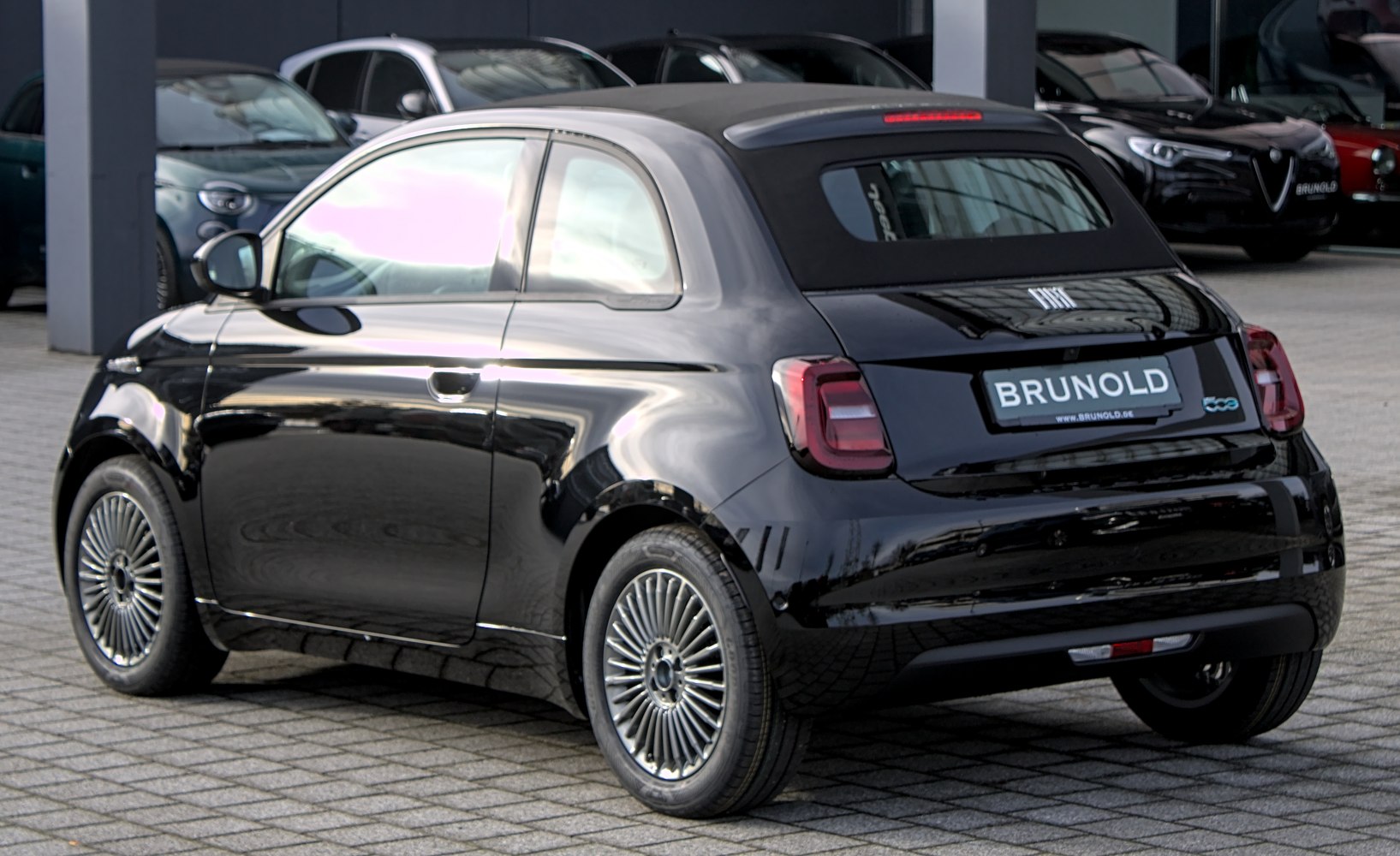 Rear and side view of sleek black electric compact convertible with distinct taillights and alloy wheels