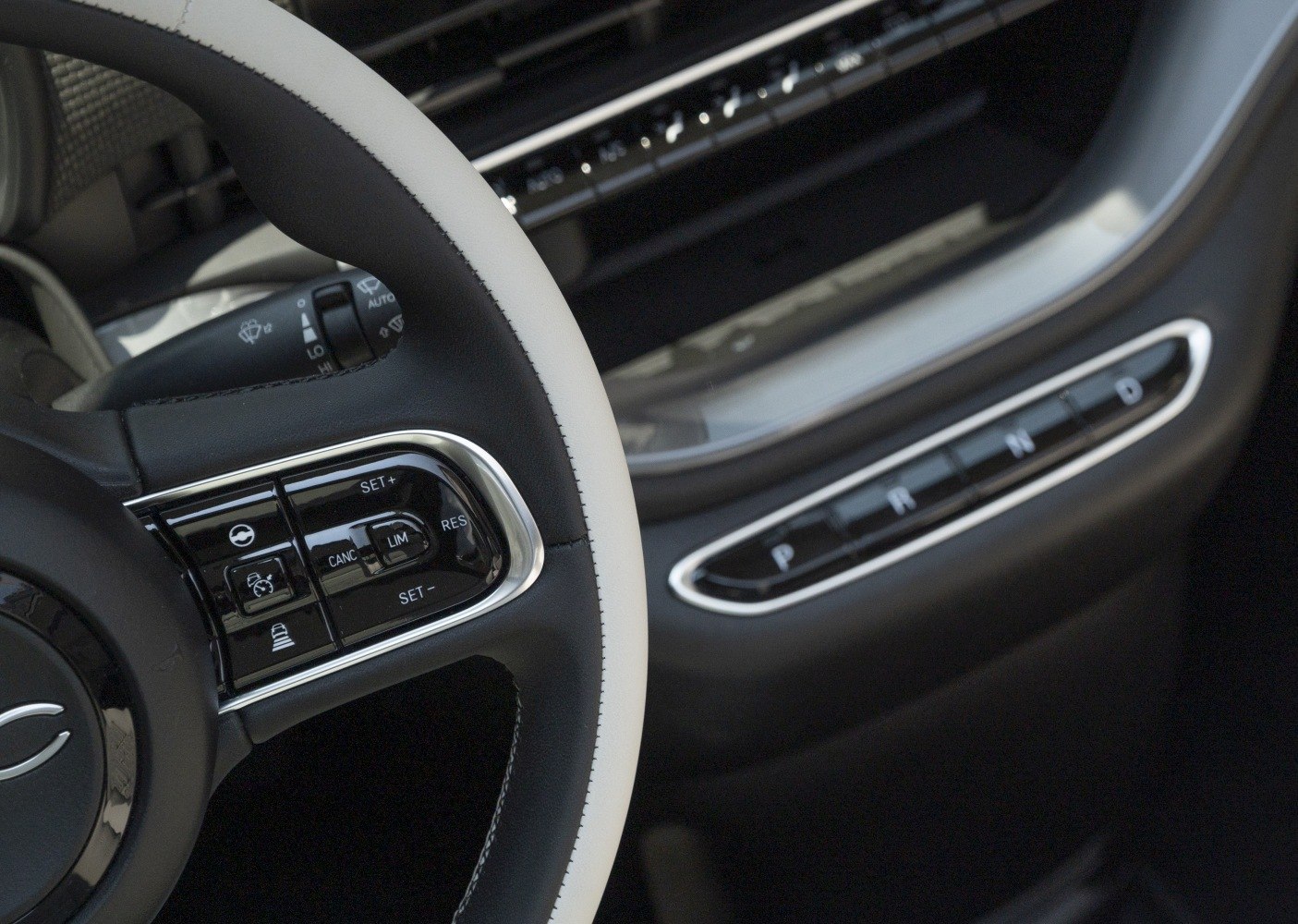 Close-up of steering wheel controls and electronic gear selector in car interior