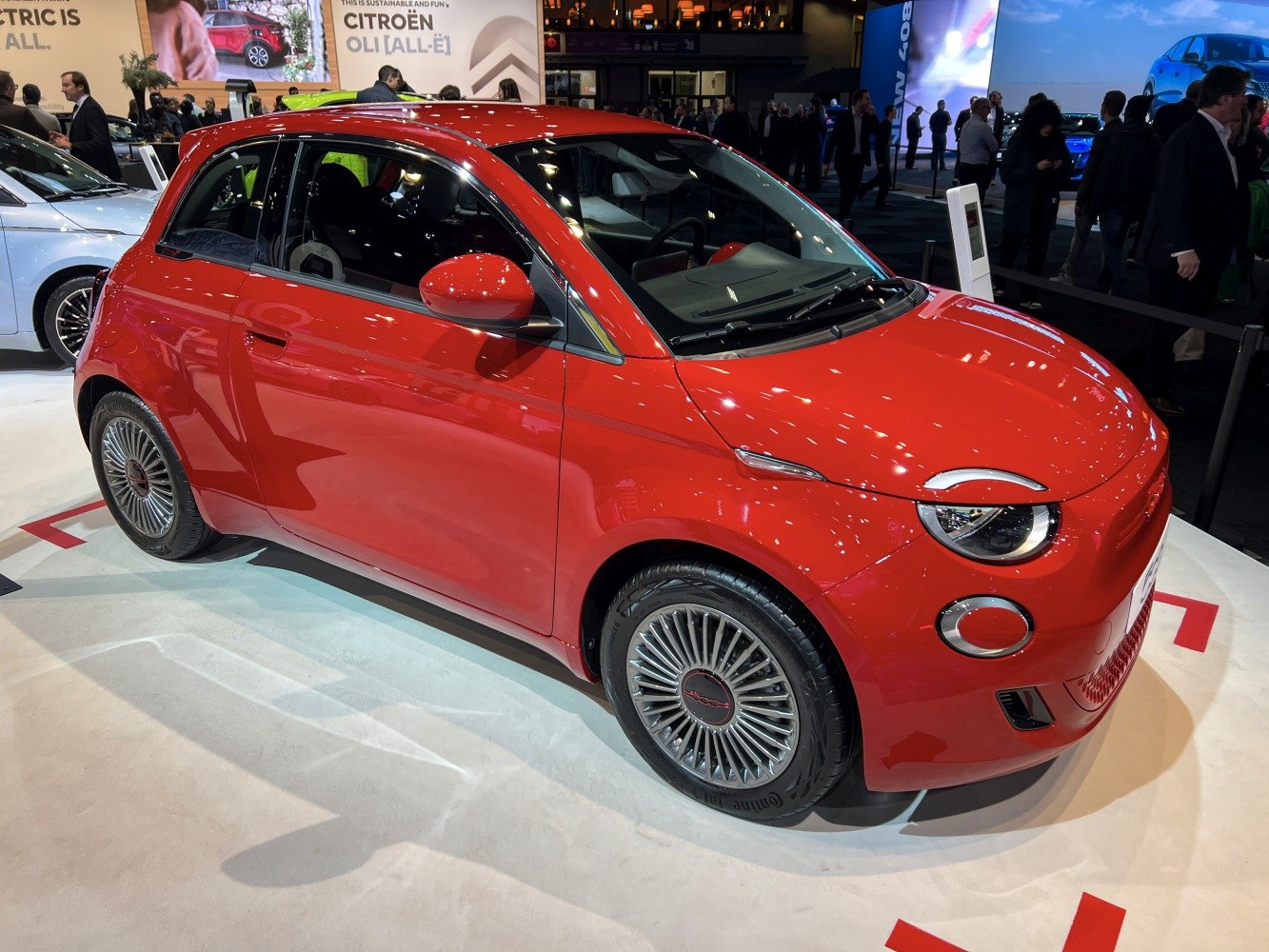 Red compact electric hatchback with turbine alloy wheels and futuristic headlights