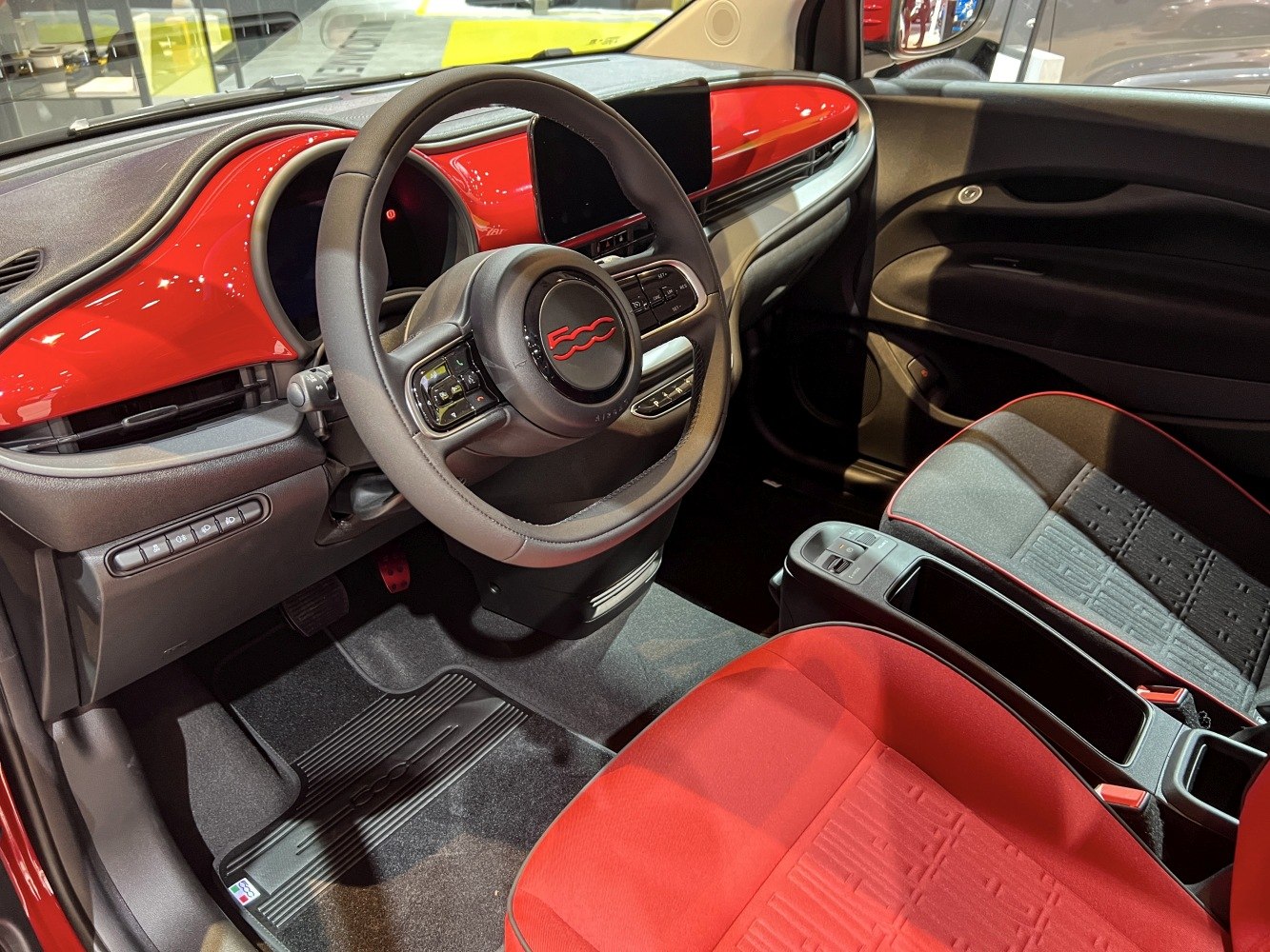 Dashboard, steering wheel, and red-black seat trim in vehicle interior
