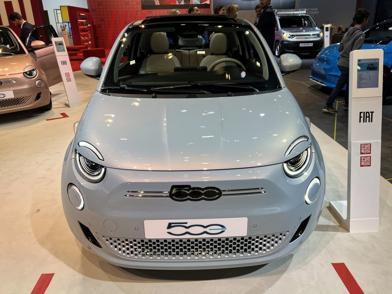 Front view of an electric car with round LED headlights and sleek grille.