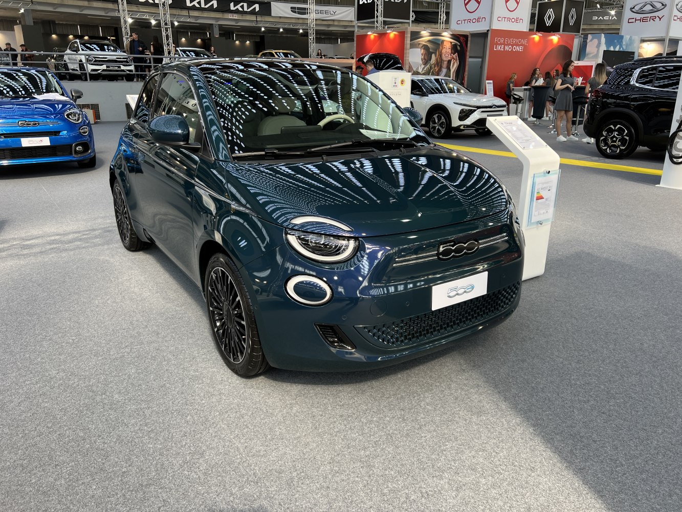 Front and side view of a compact electric vehicle with distinctive LED headlights and unique front grille design