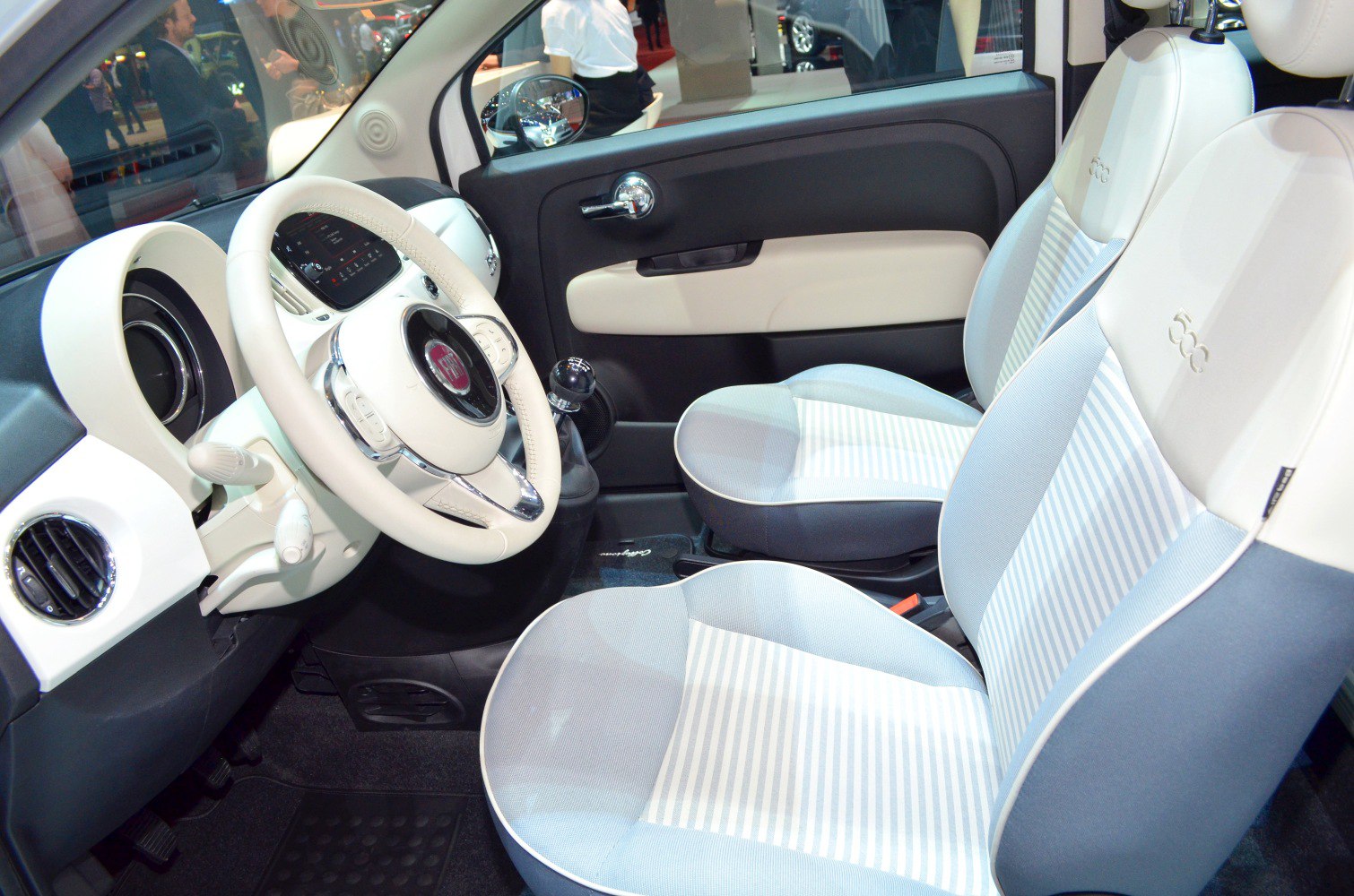 Close-up of dashboard, steering wheel, and front seats with striped fabric upholstery