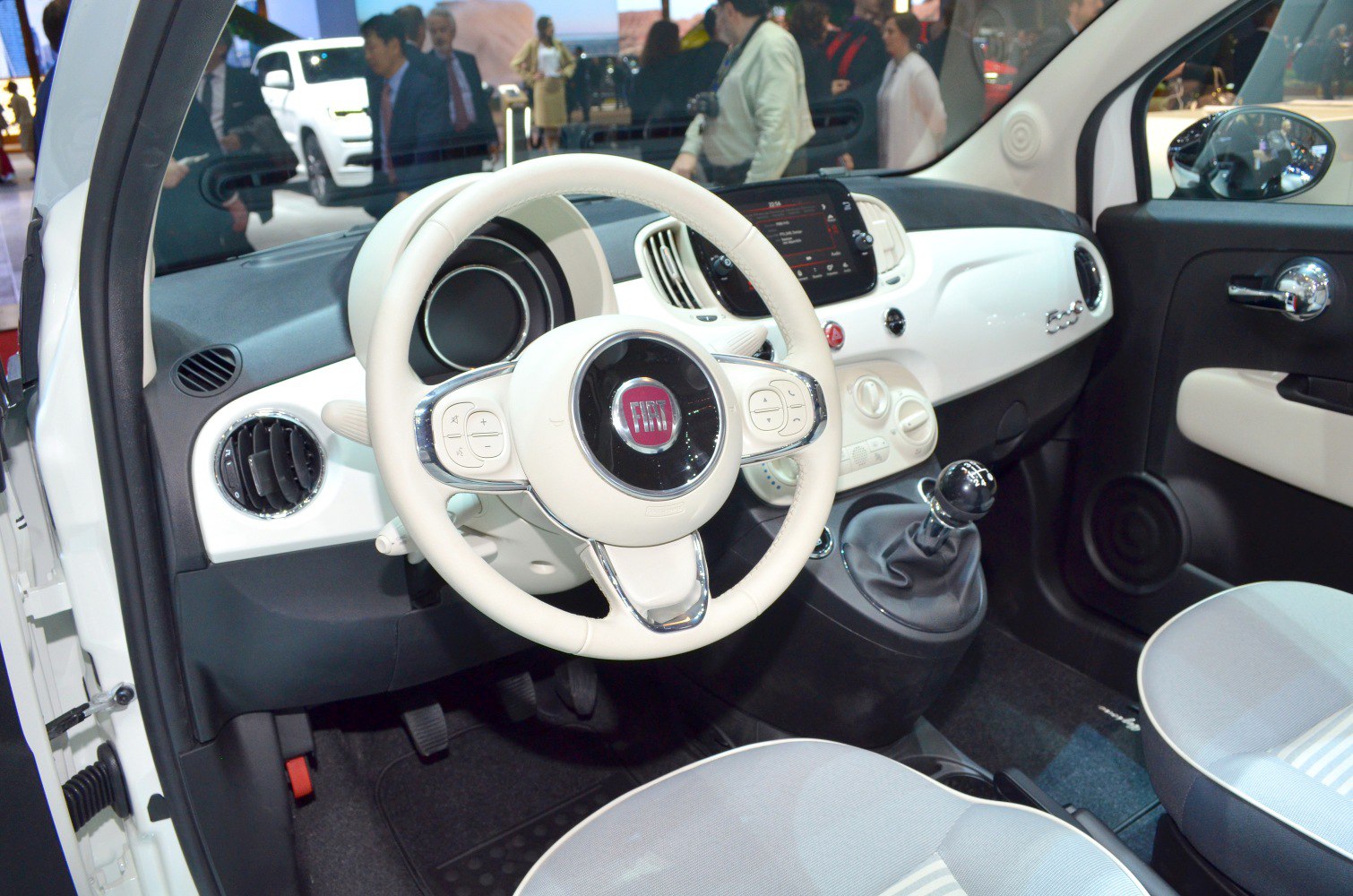 White interior dashboard, steering wheel, and manual gear shift