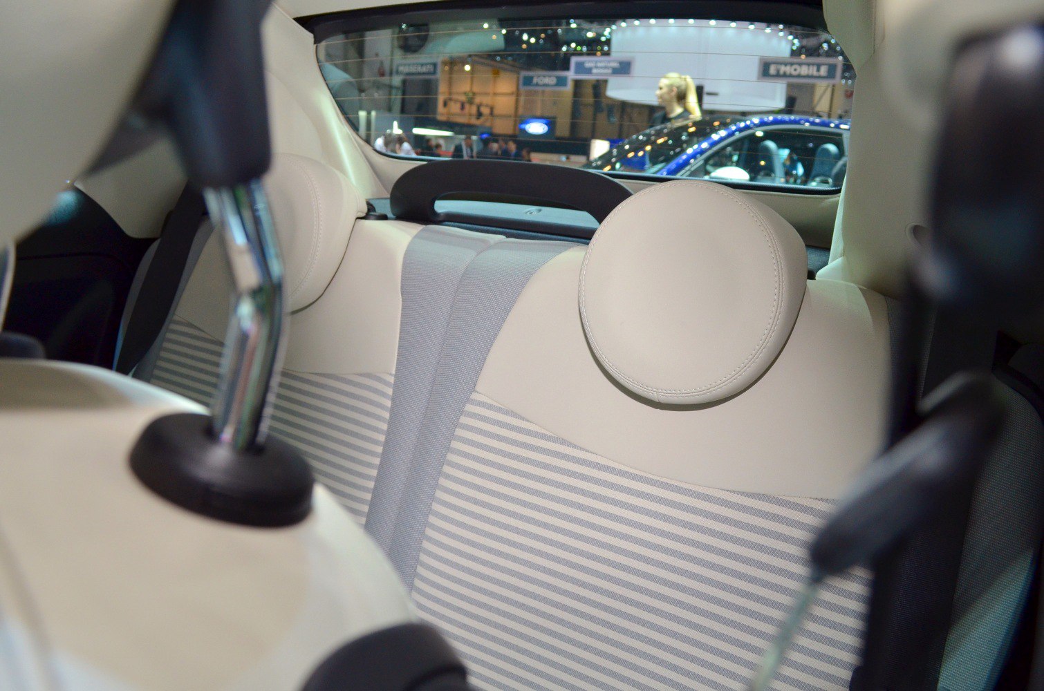 Beige rear seat upholstery with round headrests and detailed stitching