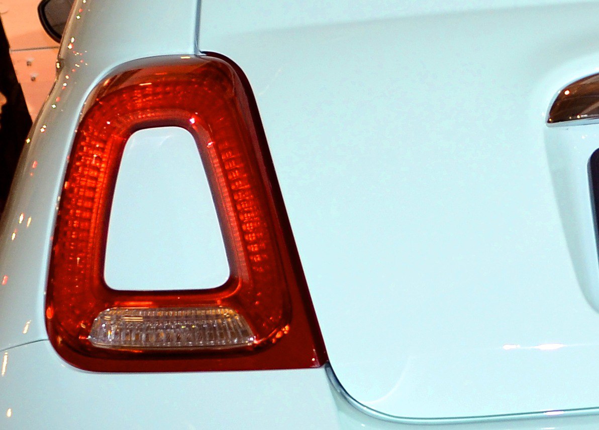 Close-up of a uniquely shaped red rear taillight on a compact car.