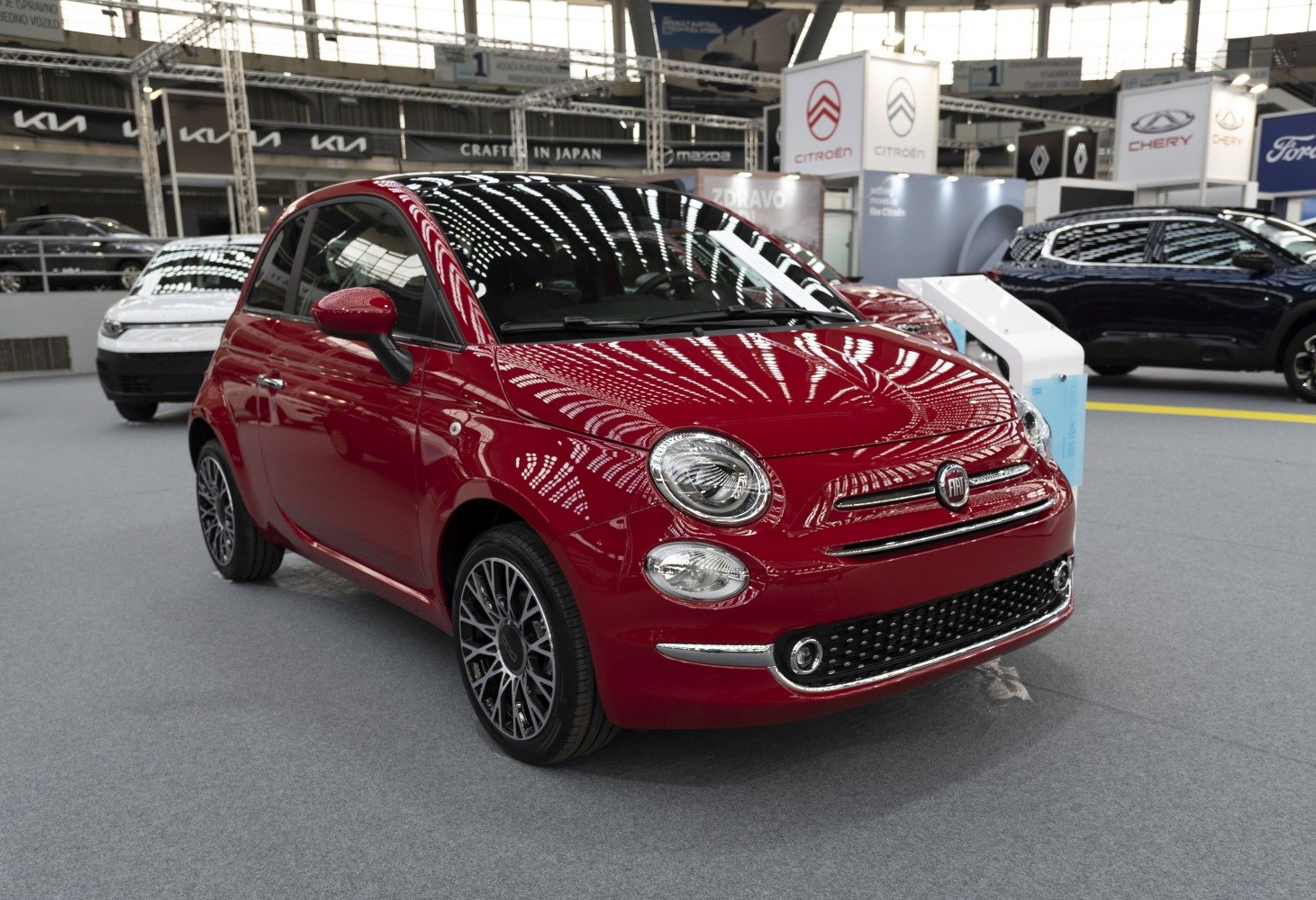 Red compact hatchback with round headlights and alloy wheels