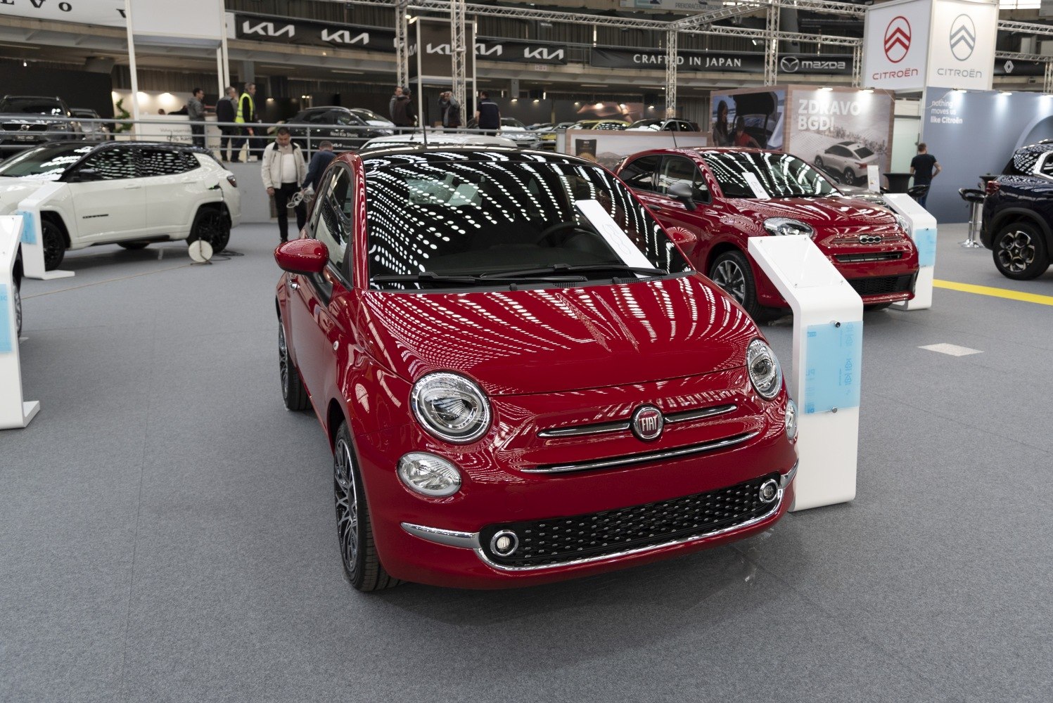 Compact red hatchback with round LED headlights and chrome front grille