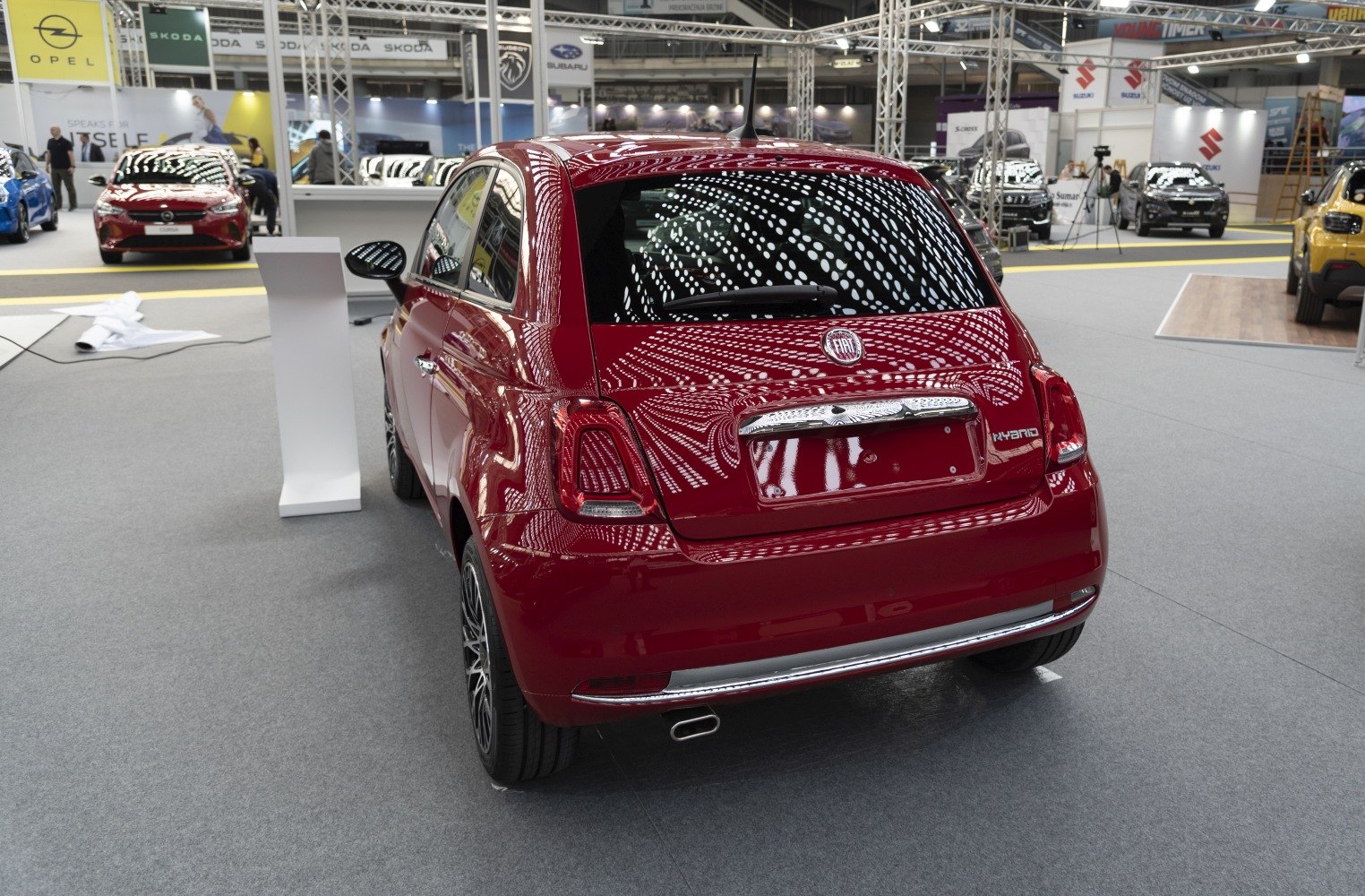 Red compact hatchback rear with hybrid badge and unique taillights