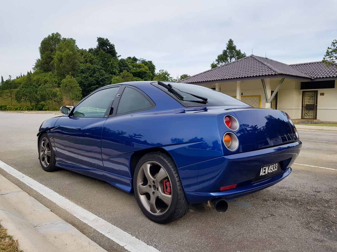 Sporty rear side profile with distinctive round taillights and alloy wheels.