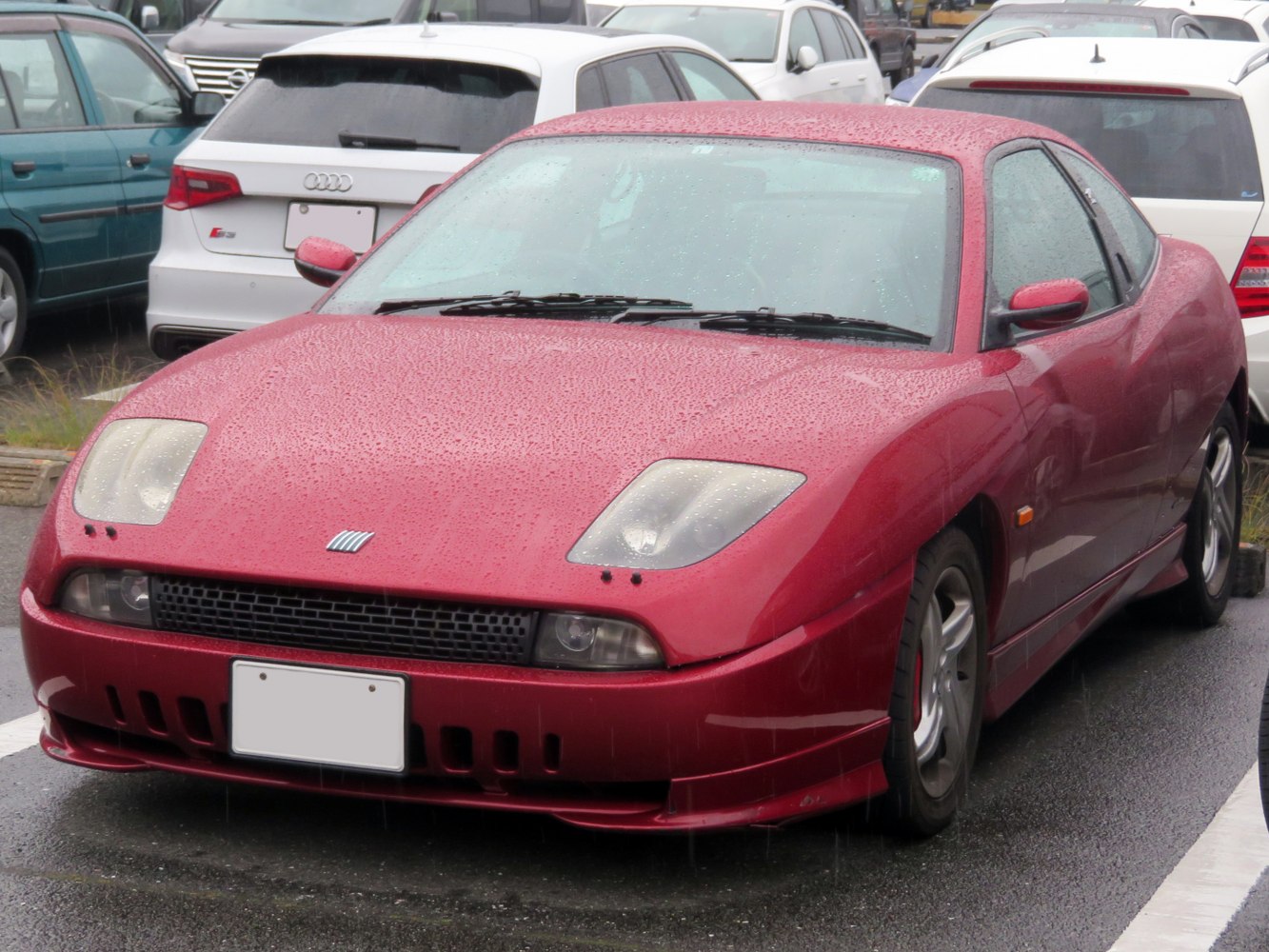 Front view of red coupe with aerodynamic shape and distinctive headlights