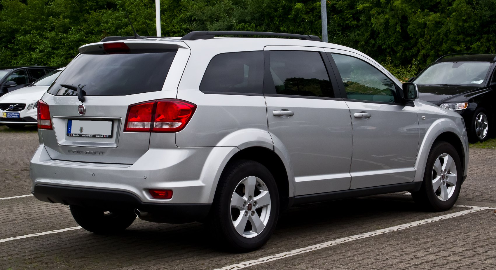 Silver SUV rear side view with tinted windows and roof rails