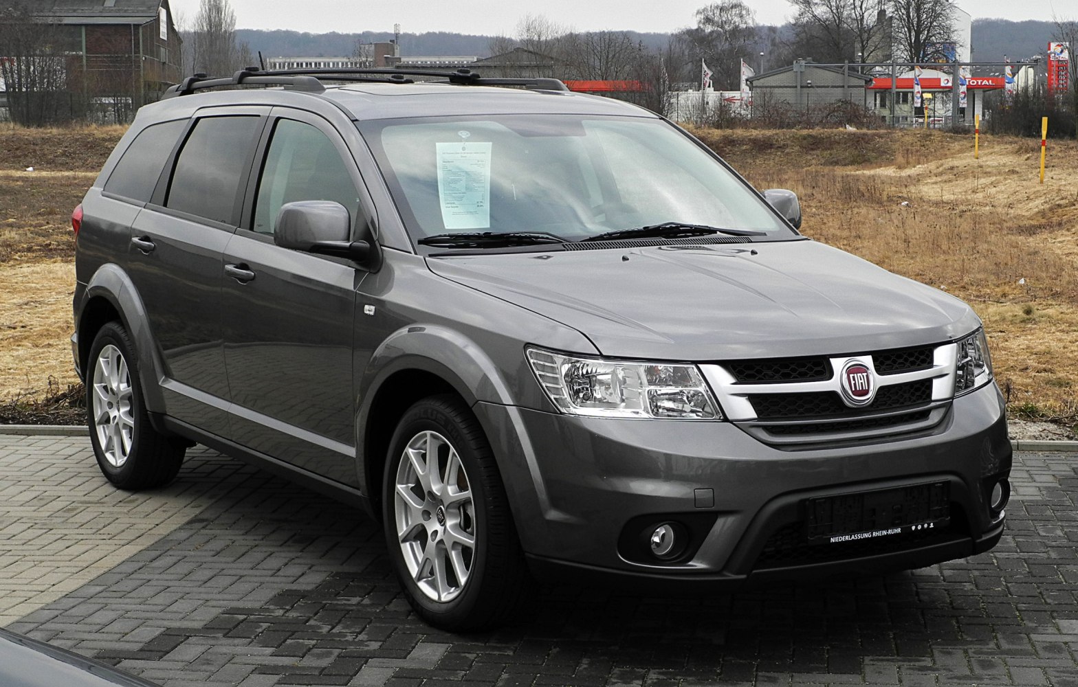 Front side view of gray SUV with roof rails and alloy wheels